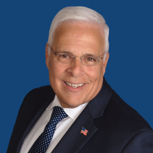 headshot of Tony Nuzio in a suit and tie