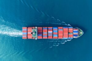 Aerial top view of a large cargo ship fully loaded with colorful shipping containers