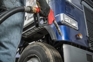 trucker near truck holding gas valve